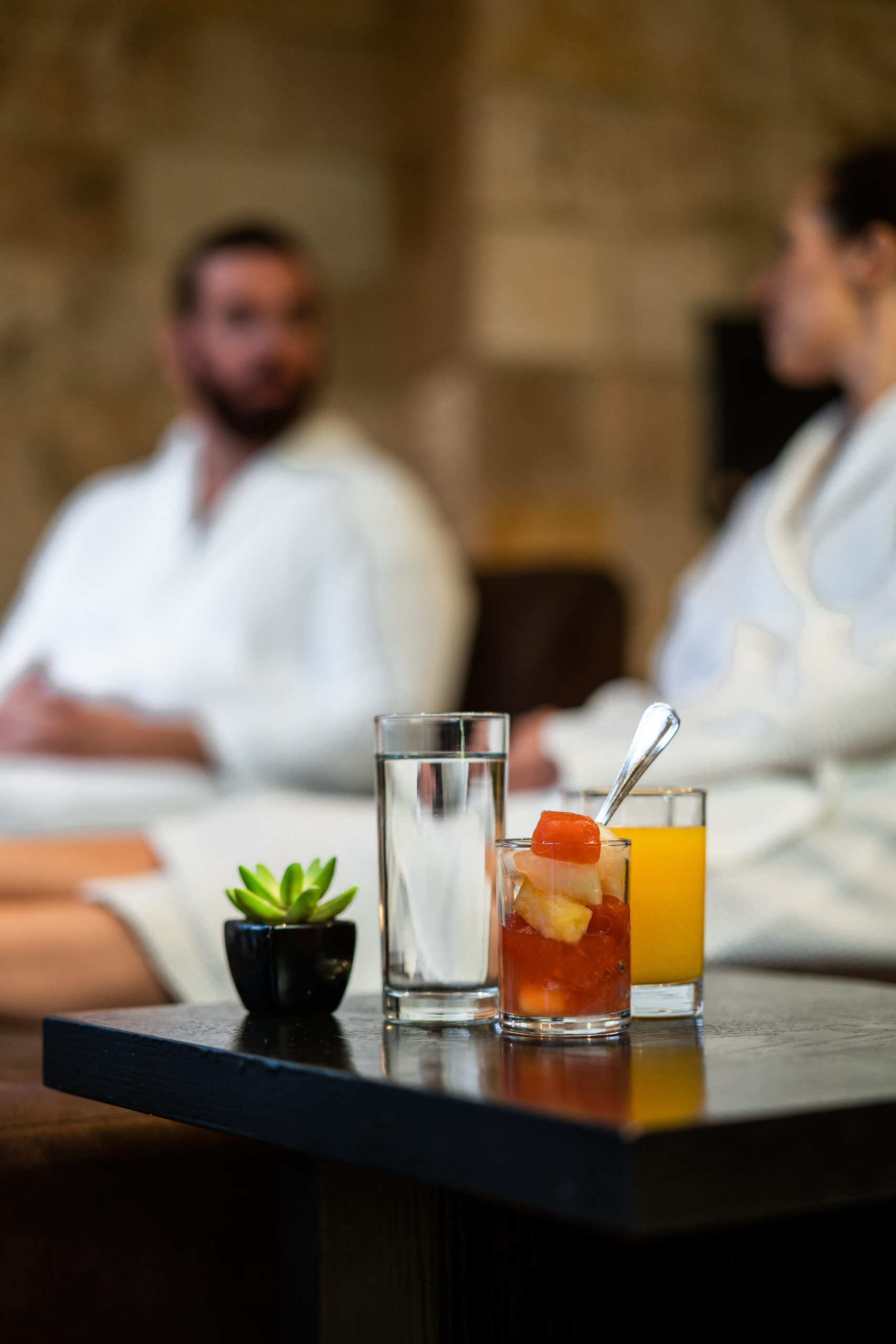Couple in spa robes relaxing with drinks
