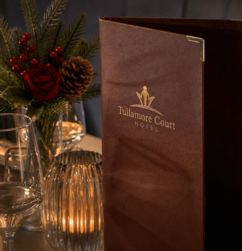 Elegant dining setup with Tullamore Court Hotel menu and festive decor.
