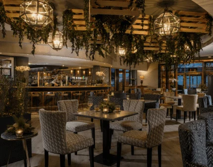 Cosy hotel lounge with ambient lighting and seating, inviting for visitors to relax and socialise.