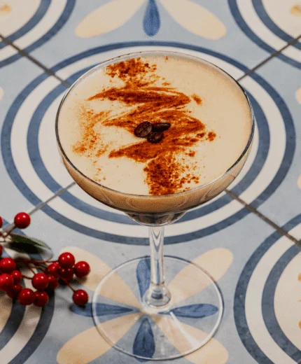 Elegant cocktail on floral tile with red berries