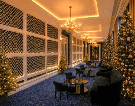 Elegant hotel lounge adorned with sparkling Christmas trees and cosy seating.