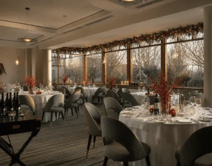 Elegant hotel dining room with festive decor and panoramic views.