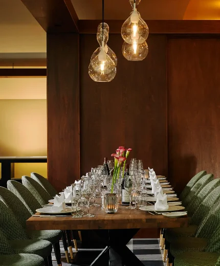 Table set for a family dinner in a cosy, elegant dining room with soft lighting.
