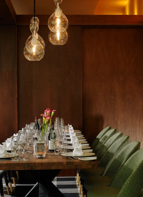 Table set for a family dinner in a cosy, elegant dining room with soft lighting.