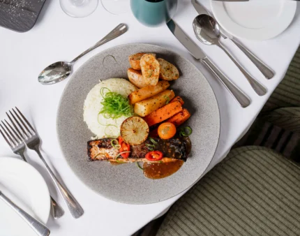 Delicious gourmet dish with roasted vegetables in a hotel dining setting.