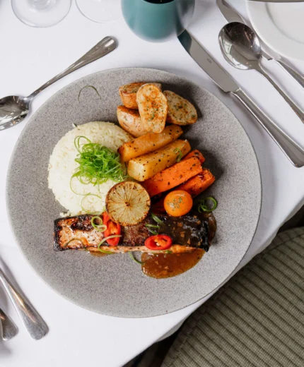 Delicious gourmet dish with roasted vegetables in a hotel dining setting.