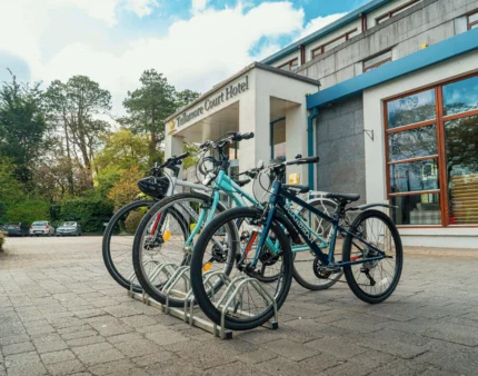 Bicycles parked outside a hotel entrance under a blue sky.