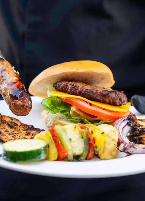 Family enjoying a grilled meal at a cosy outdoor resort setting.