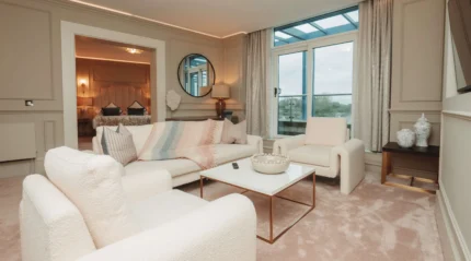 Cosy living area in luxury hotel suite overlooking scenic views. Modern decor and comfortable seating.