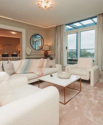 Cosy living area in luxury hotel suite overlooking scenic views. Modern decor and comfortable seating.