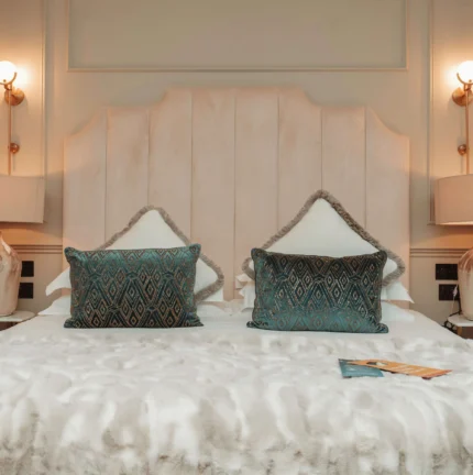 Elegant hotel room with plush bedding and soft lighting for a cosy stay.