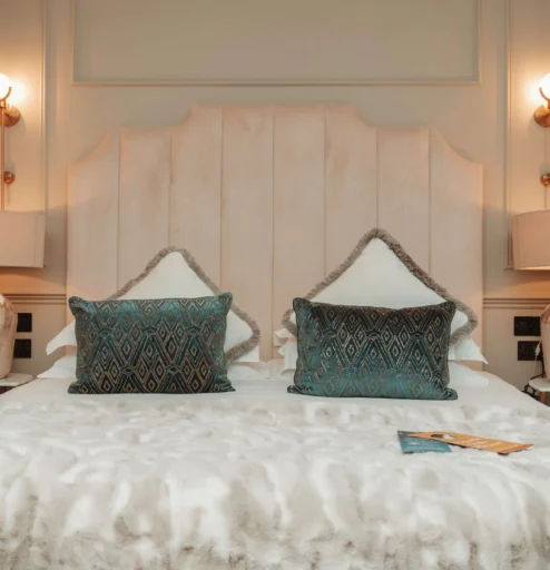 Elegant hotel room with plush bedding and soft lighting for a cosy stay.