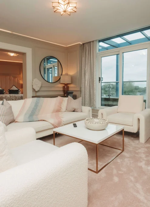 Elegant hotel suite with plush seating and scenic balcony view.