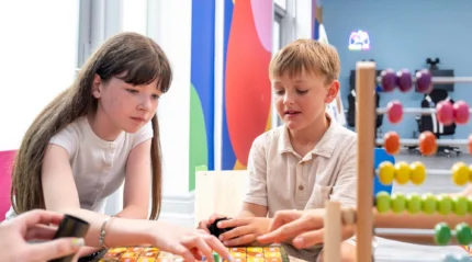 Children playing board games in a bright, colourful play area at a hotel resort.