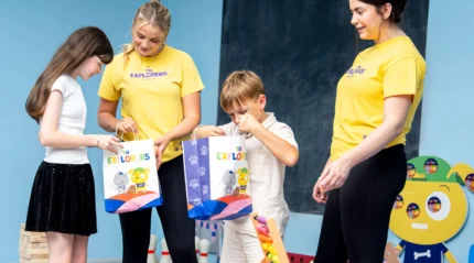 Smiling family opening gift bags at a hotel kids' club.