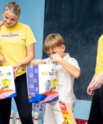 Smiling family opening gift bags at a hotel kids' club.