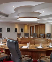 Elegant round conference room with leather chairs, set for a meeting at a luxury hotel.