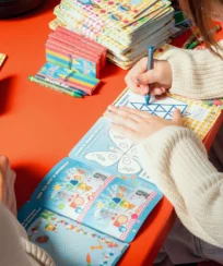 Family enjoying colourful activity books at a cosy hotel.