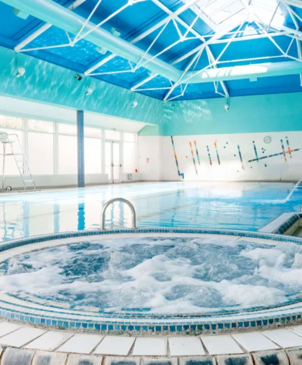 Family enjoying indoor pool and jacuzzi at modern resort