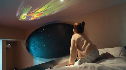 Family enjoying starry projection in cosy, inviting hotel room.