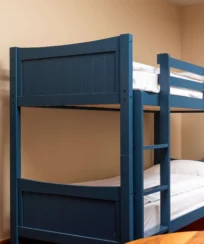 Cosy blue bunk bed in a welcoming hotel room with natural light from the window.