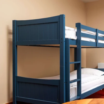 Cosy blue bunk bed in a welcoming hotel room with natural light from the window.