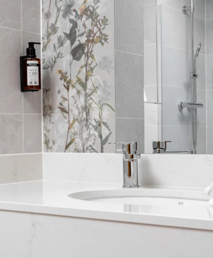 Elegant hotel bathroom with floral tiles and modern amenities.