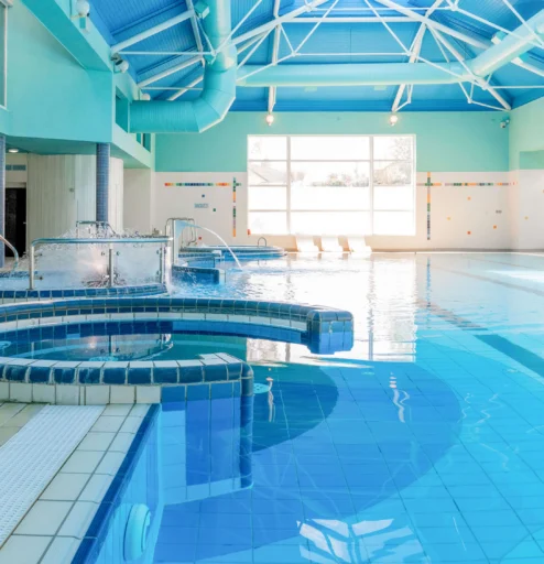 A serene indoor hotel pool with spa features, inviting guests to relax and unwind.