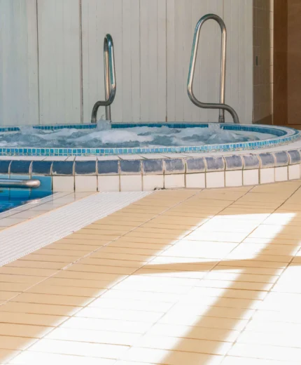 Inviting indoor hotel pool and spa area with sunlight streaming in