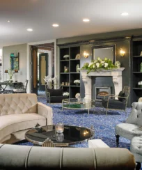 Elegant hotel lounge with plush sofas, fireplace, and decorative flowers, ideal for relaxation.