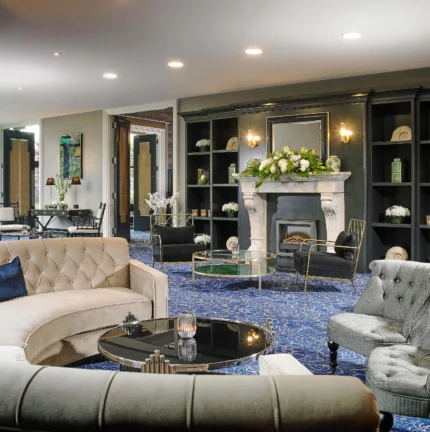 Elegant hotel lounge with plush sofas, fireplace, and decorative flowers, ideal for relaxation.
