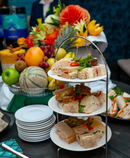 Afternoon tea with assorted sandwiches and fresh fruits in a cosy hotel setting.