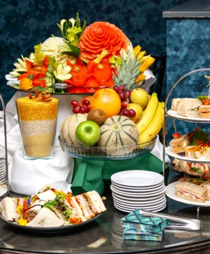 Elegant afternoon tea with sandwiches and fresh fruit display.