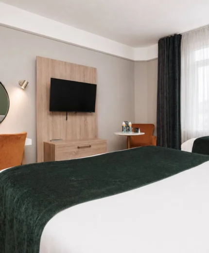 Modern hotel room with twin beds and a relaxing sitting area.