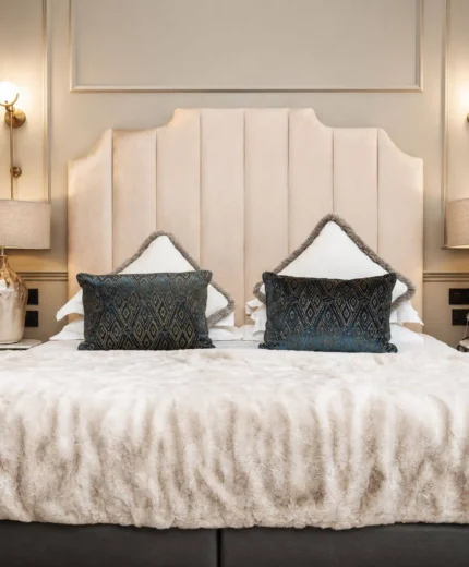 Luxurious hotel room with plush bed and elegant decor, creating a warm and inviting ambiance.