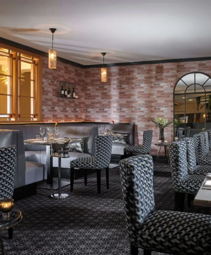 Cosy hotel dining area with elegant tables and warm lighting.