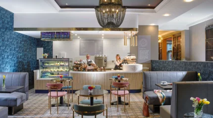 A cosy hotel café with a welcoming ambience, featuring a couple enjoying coffee.