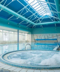 Relaxing pool and jacuzzi in bright hotel leisure area.