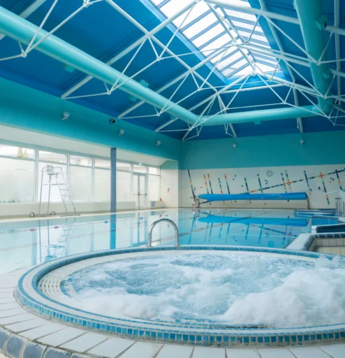 Relaxing pool and jacuzzi in bright hotel leisure area.