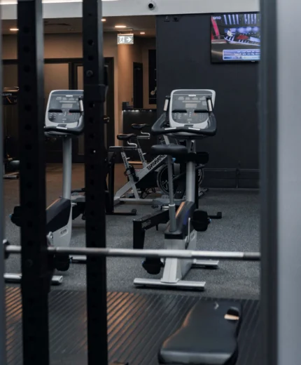 Modern hotel gym with exercise bikes and a TV, inviting guests to stay active.