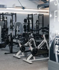 Modern fitness centre with exercise bikes and weightlifting equipment.