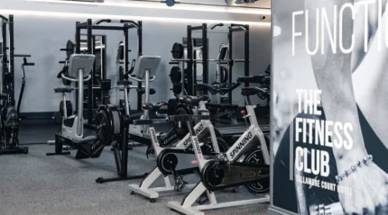 Modern fitness centre with exercise bikes and weightlifting equipment.