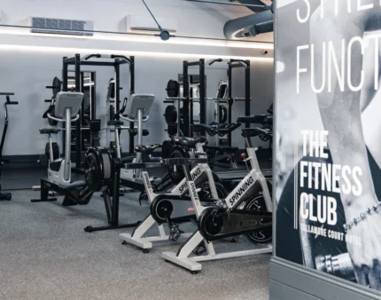 Modern fitness centre with exercise bikes and weightlifting equipment.