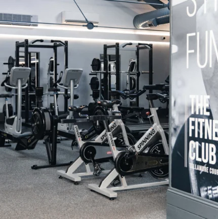 Modern fitness centre with exercise bikes and weightlifting equipment.