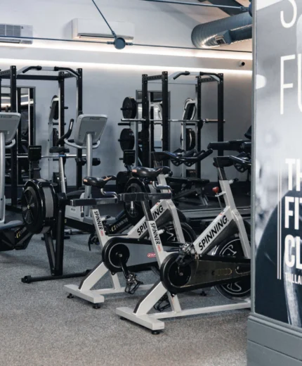 Modern fitness centre with exercise bikes and weightlifting equipment.
