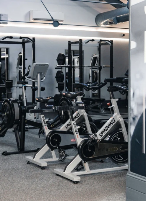 Modern fitness centre with exercise bikes and weightlifting equipment.