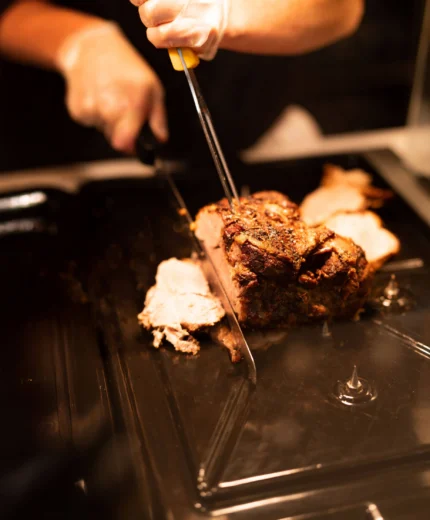 Chef carving roast beef at hotel buffet, inviting a warm dining experience.