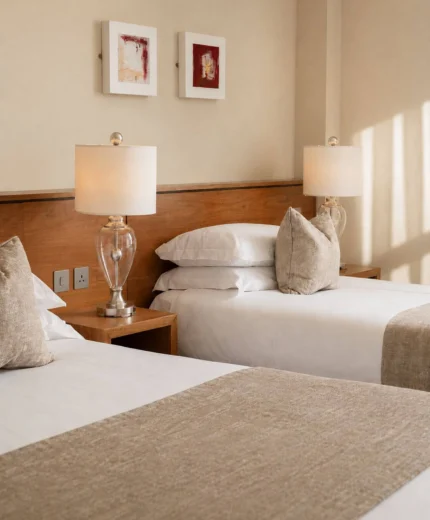 Cosy hotel room with twin beds and warm lighting.