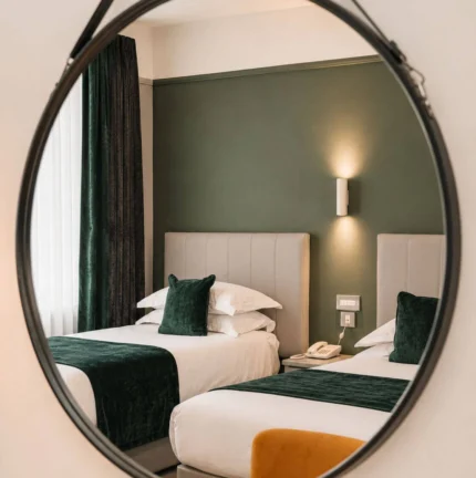 Cosy hotel room with twin beds and elegant decor.