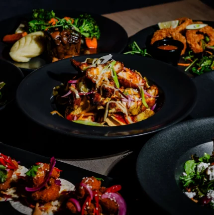 A warm family meal in a cosy restaurant setting with a variety of vibrant dishes.